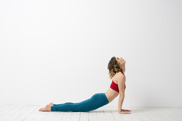 Fototapeta premium woman in leggings is engaged in gymnastics in a light room slim figure fitness sport