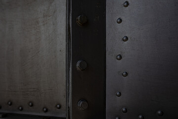 Metal sheet, garage part, wall screwed in with bolts, nuts, screws, traces of silver paint with elements of rust and metal corrosion, cracks.