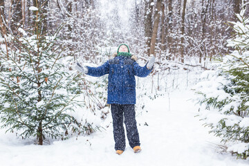 Happy boy throwing snow. Child, season and winter concept.