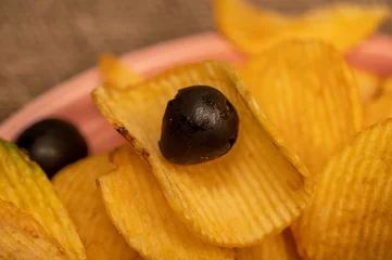 Foto op Plexiglas Crispy, delicious potato chips with mustard sauce and olives on a coarse homespun cloth. Close up. © Андрей Захаров