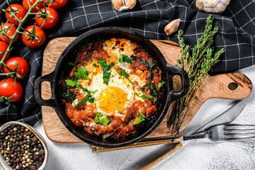 Breakfast with Fried eggs, tomatoes. Shakshuka in pan. Turkish  traditional dishes. Gray background. Top view