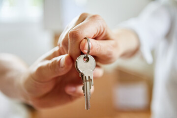 Hands of couple hold keys to new house