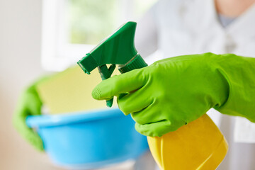 Hands with gloves and glass cleaner