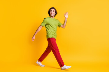 Fototapeta na wymiar Full length body size photo of man wearing canvas shoes waving with hand greeting isolated on bright yellow color background
