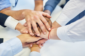 Managers stack hands at business team building