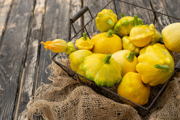Patisson, Squash, dish-shaped pumpkin, raw vegetable on a dark wooden background.