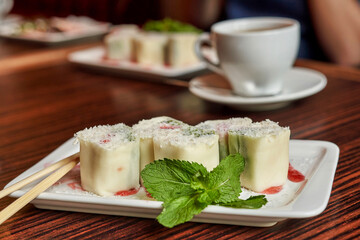 Sweet minari rolls on a white dish with a mint leaf