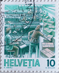 Switzerland - Circa 1986 : a postage stamp printed in the swiss showing some women sorting parcels in a parcel distribution system