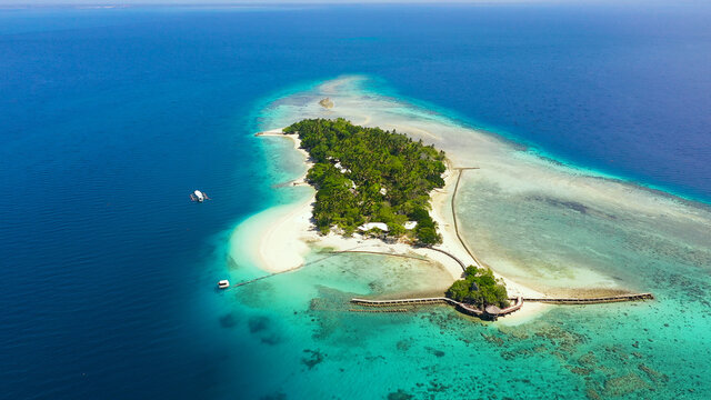 Little Liguid Island with beautiful beach, palm trees by turquoise water view from above. Little Cruz Island, Philippines, Samal.