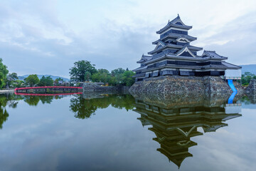 Naklejka premium Sunrise view of Matsumoto Castle (Crow Castle) and bridge