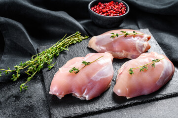 Chicken thigh fillet without skin. Black background. Top view
