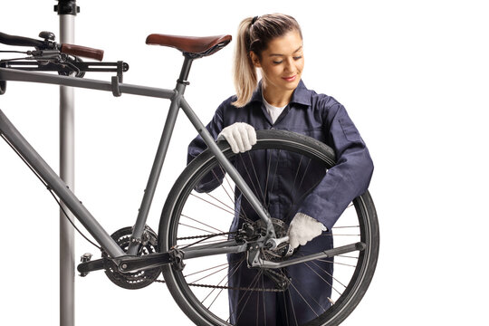 Female bike mechanic repairing fastening bicycle wheel