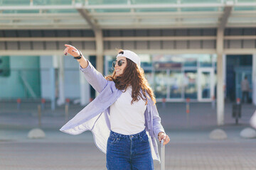 A young beautiful girl student leaves the airport in a new city, and waits for a taxi