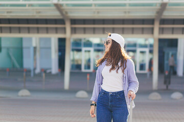 Naklejka premium A young beautiful girl student leaves the airport in a new city, and waits for a taxi