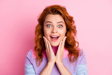Photo portrait of shocked woman with open mouth touching face cheeks with two hands isolated on pastel pink colored background