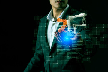 Man and augmented reality innovation technology engineer robot arm with artificial intelligence controlling futuristic smart factory digital technology. Business man in suit hand holding robot