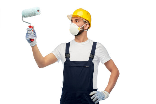 profession, construction and building - male worker or builder in yellow helmet and respirator with paint roller over white background