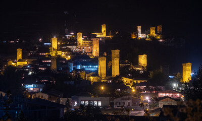 Obraz premium Night panoramic view of a highland townlet Mestia with illuminated svan towers, Svaneti, Georgia.