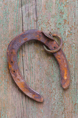 old horseshoe laying on wooden plank