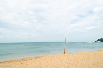 Beach volleyball net on fine sand with blue sea