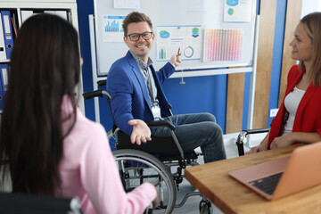 Businessman in wheelchair holds business conference in office. Small and medium business...