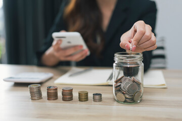 saving money with hand putting coins in jug glass concept financial