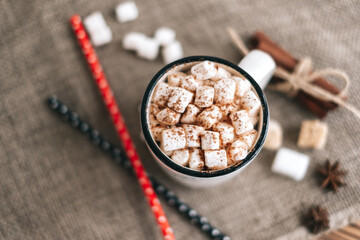Hot cocoa with marshmallows on wooden board.