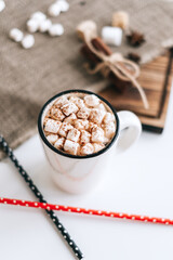 Hot cocoa with marshmallows on white table.