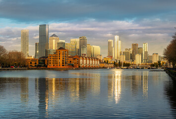 Canary Wharf and South Dock Marina place reflected in the Thames rives in sunset light in London