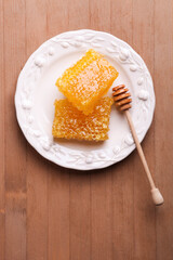 Golden cut honeycomb with a wooden spoon