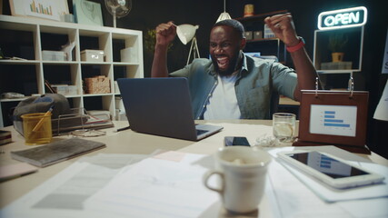 Satisfied african american businessman making yes gesture in modern coworking.