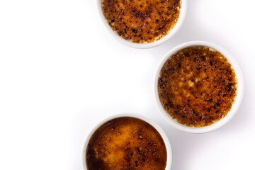 Homemade creme brulee in bowl isolated on white background. Top view. Copy space