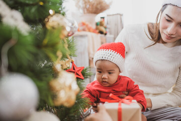 merry christmas and happy Holidays. mother held her daughter near the christmas tree and decorate the christmas tree indoors. the morning before Xmas. Portrait loving family close up.