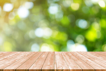 Wooden table with abstract blurred green garden background.