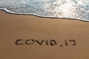 Word Covid 19  Written On The Sand  Wave and Beach Background