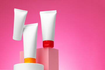 Blank white cosmetic container against pink background