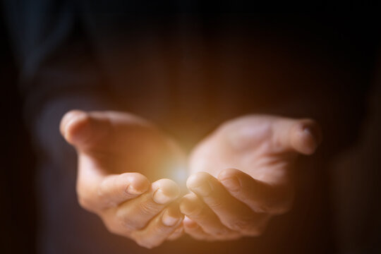 Man hands praying in dark background with faith in religion  in God. Power of hope or love.