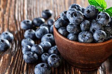 freshly picked blueberries close up with water drops on wood background