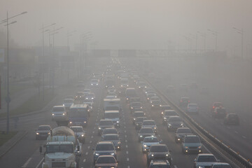 cars driving in the city in the morning mist