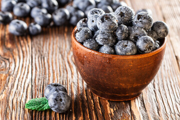 freshly picked blueberries close up with water drops on wood background
