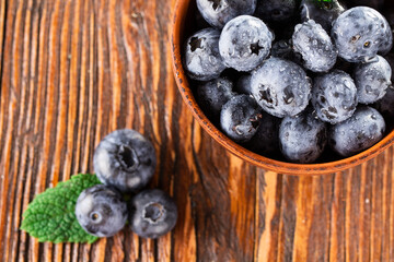 freshly picked blueberries close up with water drops on wood background