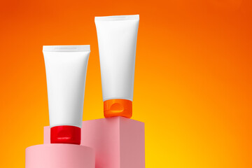 Blank white cosmetic container against orange background
