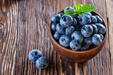 freshly picked blueberries close up with water drops on wood background