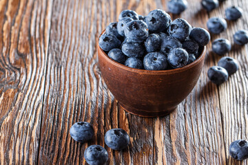 freshly picked blueberries close up with water drops on wood background