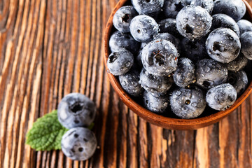 freshly picked blueberries close up with water drops on wood background