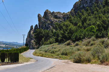 Curving empty mountain road view along rocky cliffs. Sax, province of Alicante, Valencian Community. Spain