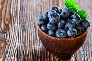 freshly picked blueberries close up with water drops on wood background