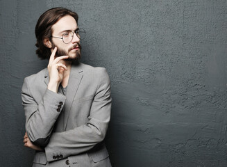 Young handsome man posing on gray wall background