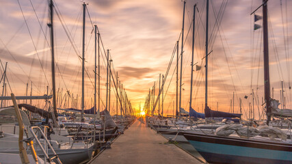 Pier at dutch harbour with sailing boats at sunset