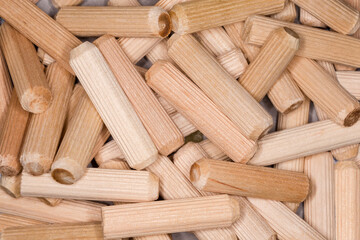 Background of pile of wooden dowel pins close-up